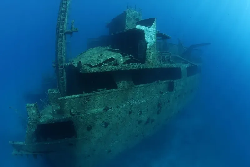 Épave de bateau coulé, colonisée par la vie marine, en bleu profond