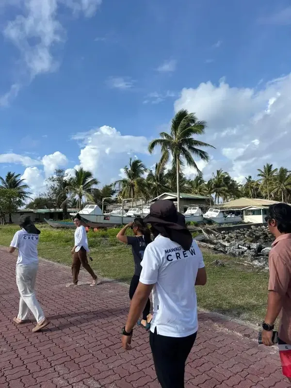 Groupe de personnes marchant sur un quai vers des bateaux de plongée