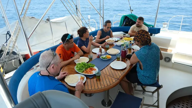 Groupe de personnes déjeunant sur le pont d'un catamaran en mer