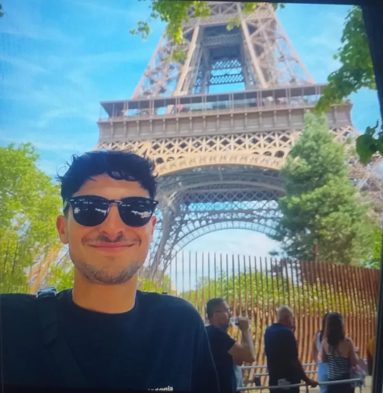 Portrait d'un homme souriant avec la Tour Eiffel en arrière-plan