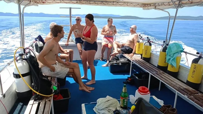 Groupe de plongeurs sur un bateau en mer, préparation de la plongée