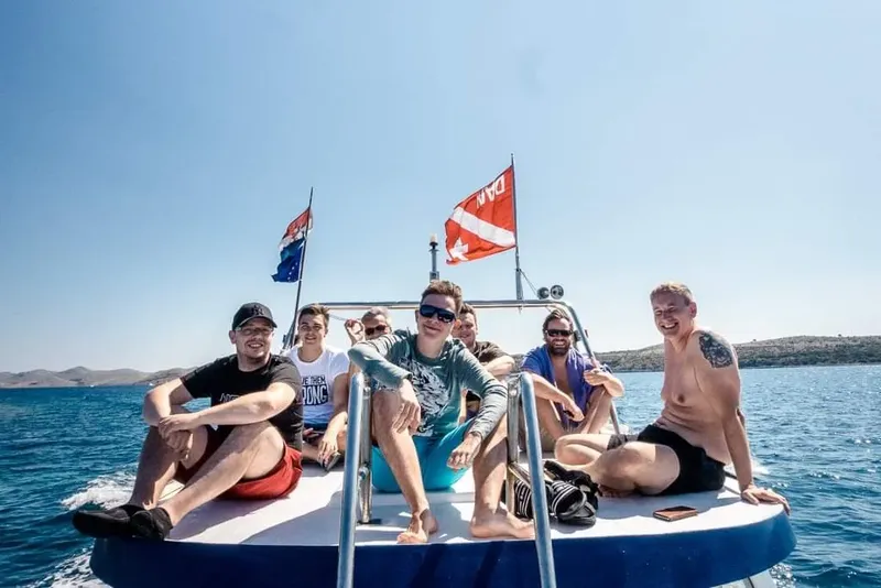 Groupe de personnes souriantes sur un bateau en mer, journée ensoleillée