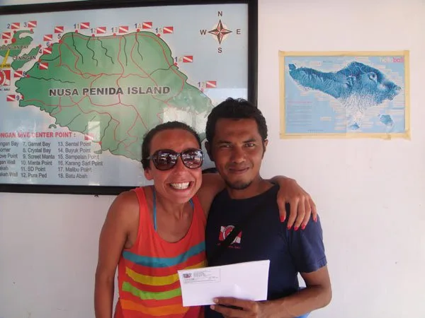 Deux personnes souriantes posent devant une carte de Nusa Penida