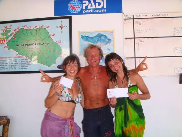 Trois personnes souriantes montrent leurs certificats de plongée PADI