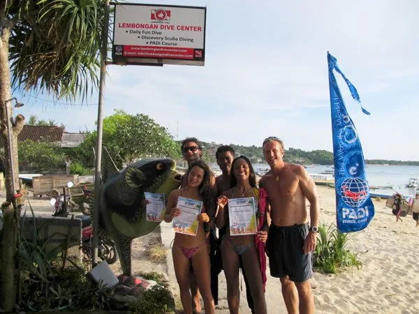 Groupe de plongeurs souriants avec leurs certificats sur une plage