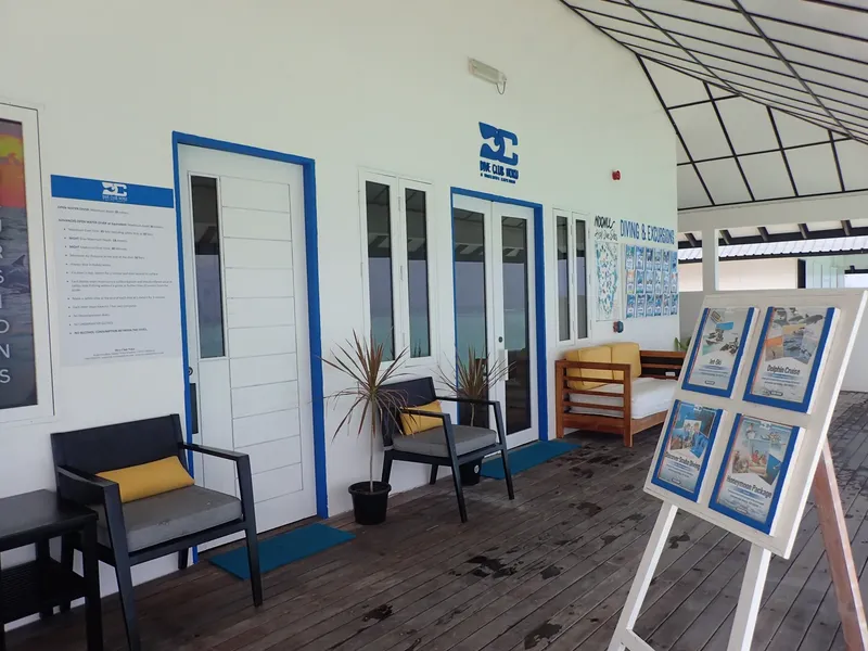 Façade d'un centre de plongée avec mobilier d'extérieur et affiches
