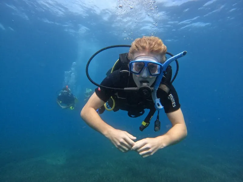 Plongeur souriant face à la caméra, en pleine exploration sous-marine