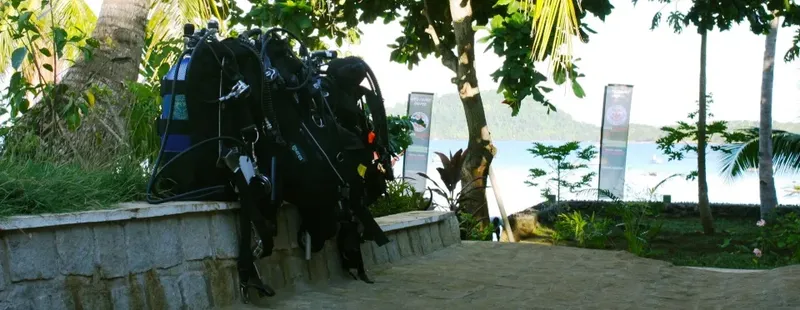 Equipement de plongée posé sur un muret face à la mer et végétation