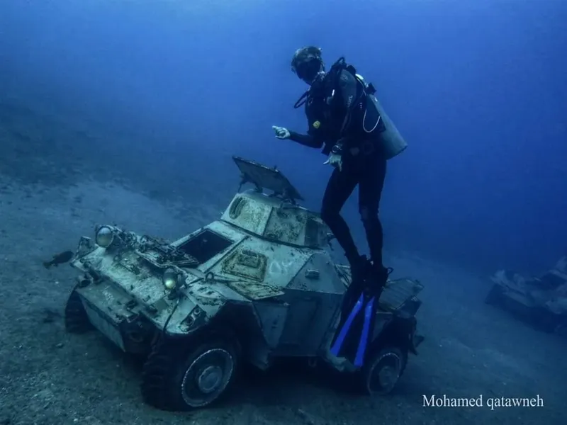 Plongeur sur un véhicule submergé, exploration sous-marine, épave rouillée