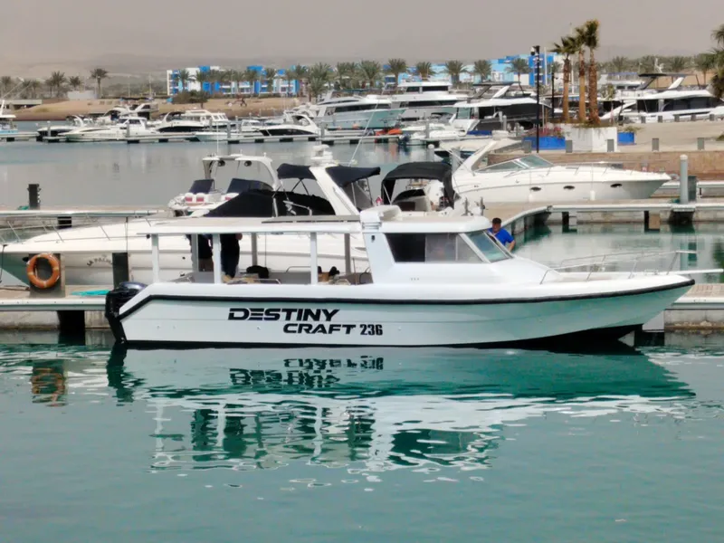 Bateau de plongée amarré dans une marina ensoleillée avec le nom Destiny Craft