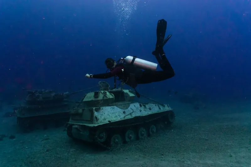 Plongeur explorant des chars d'assaut coulés au fond de la mer