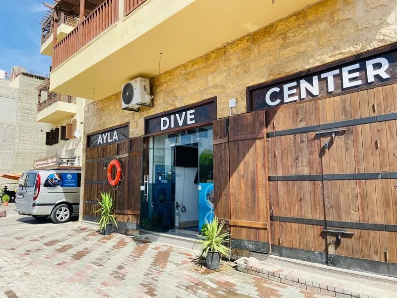 Façade d'un centre de plongée avec l'inscription 'DIVE CENTER' et un van
