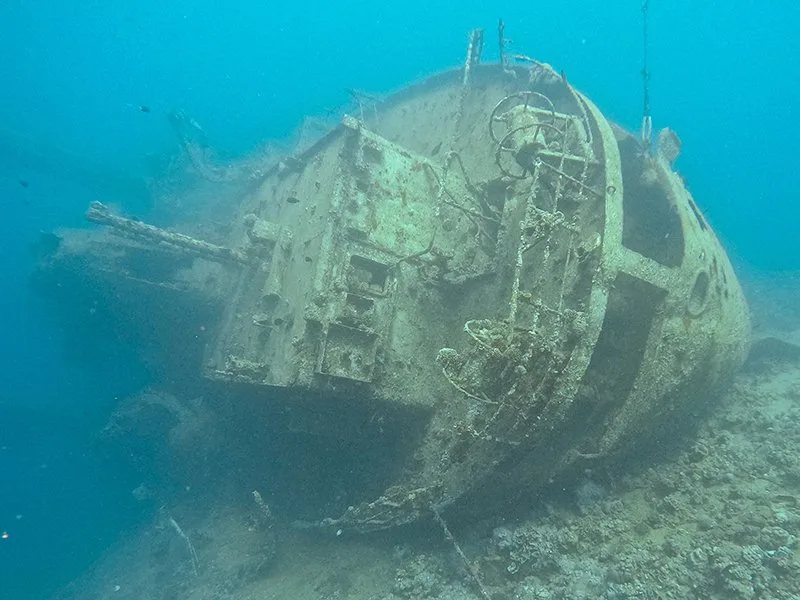 Épave de bateau rouillé reposant sur le fond marin sablonneux