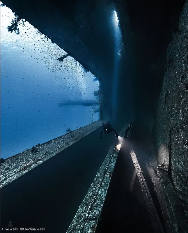 Plongeur explorant une structure sous-marine sombre et mystérieuse éclairée