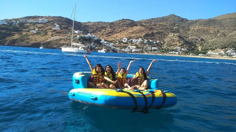 Quatre jeunes femmes s'amusent sur un bouée tractée en mer
