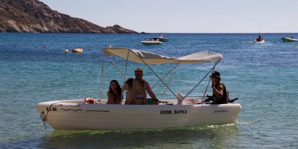 Trois personnes à bord d'un petit bateau blanc en mer