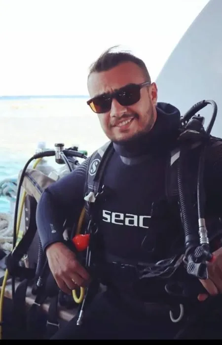 Plongeur souriant avec équipement complet sur un bateau de plongée