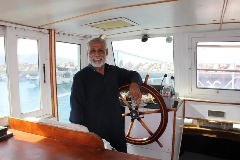 Homme souriant tenant le volant d'un bateau en mer