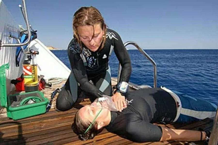 Une personne prodigue les premiers secours à un autre individu allongé