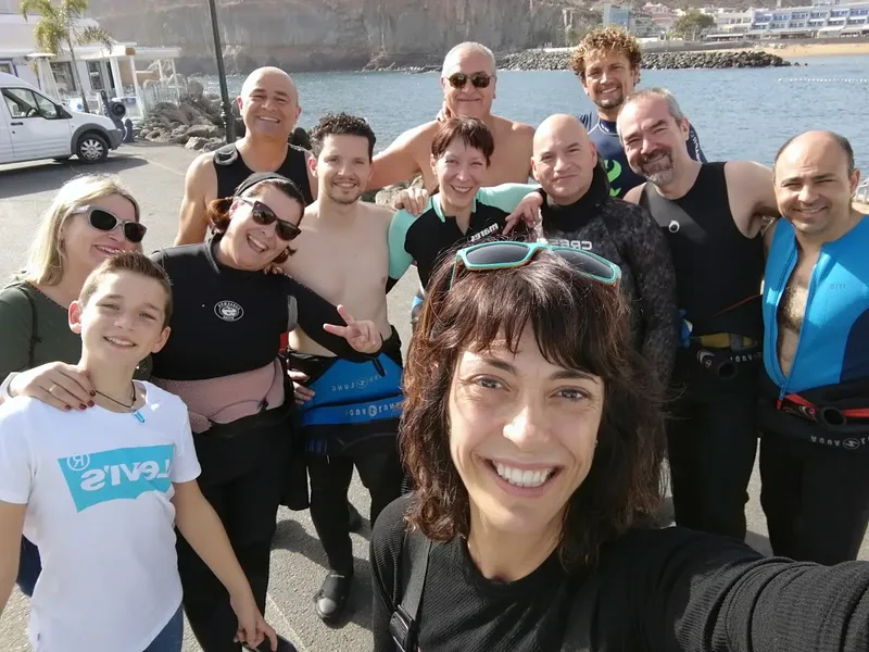 Groupe de personnes souriantes posant pour une photo en bord de mer