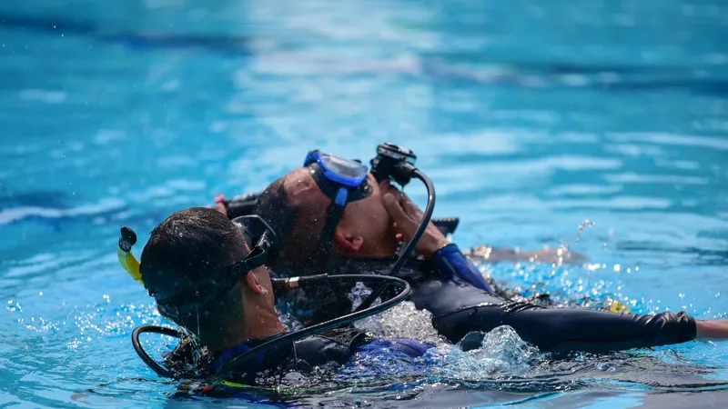 Deux plongeurs s'entraînent en piscine avec leur équipement complet