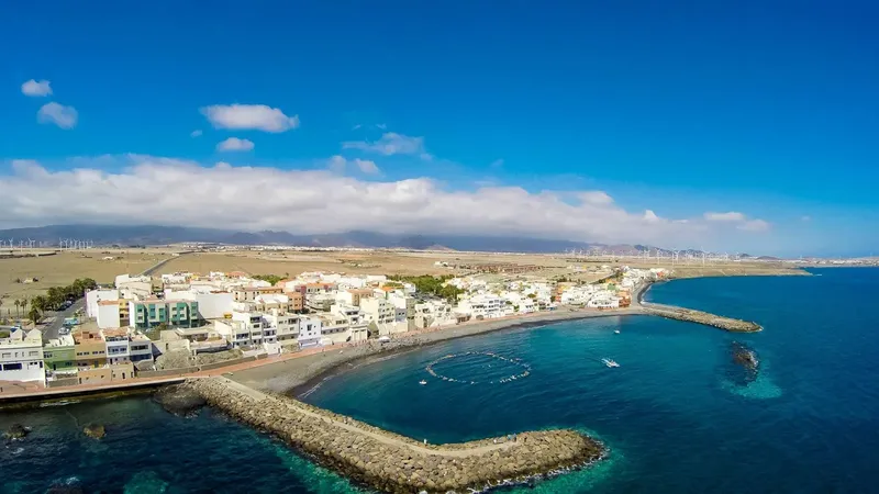 Vue aérienne d'une côte avec des bâtiments, un port et la mer