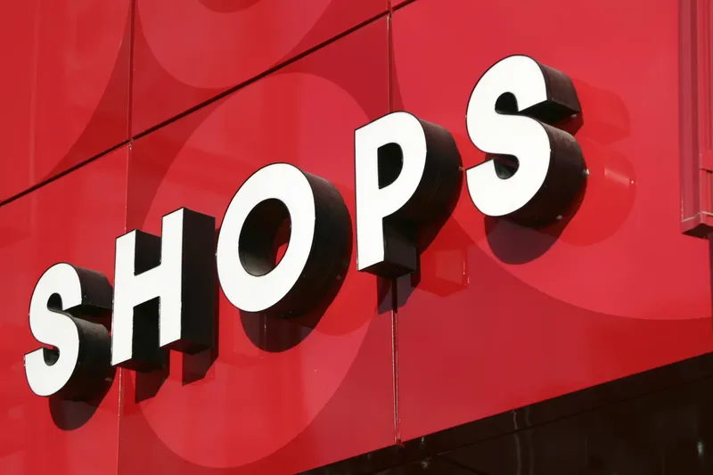 Lettres blanches volumineuses formant le mot SHOPS sur fond rouge