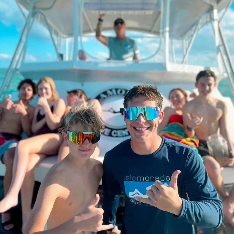 Groupe de jeunes gens souriants à bord d'un bateau de plongée