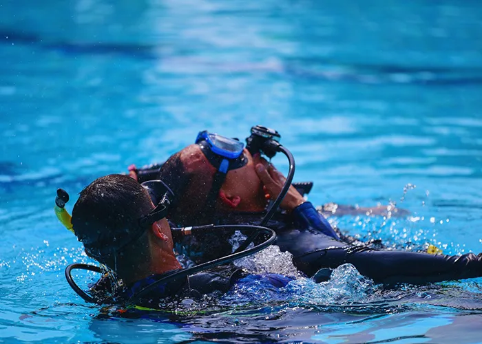 Deux plongeurs en formation flottent à la surface d'une piscine