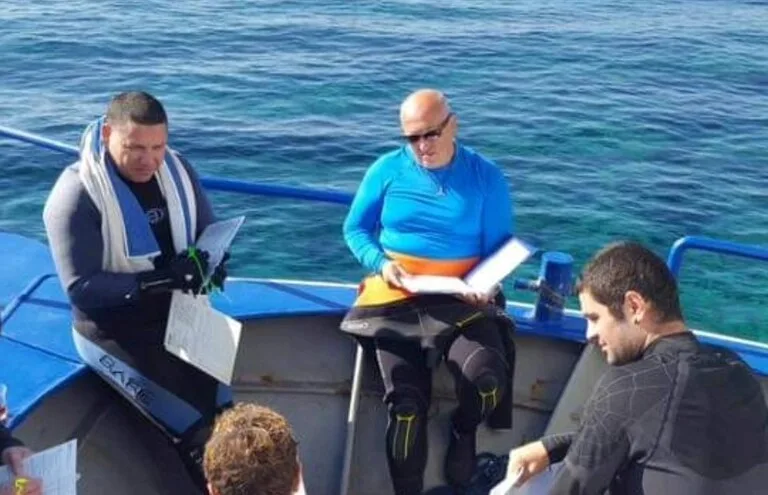 Plongeurs lisant des documents à bord d'une embarcation en mer