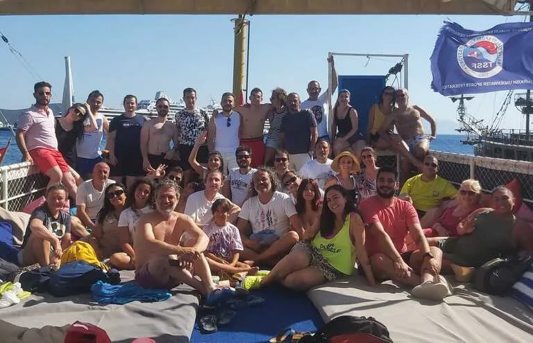 Groupe de personnes souriantes sur le pont d'un bateau de plongée