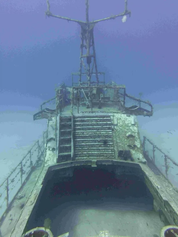 Épave de bateau immergée, vue vers le haut, structure métallique rouillée