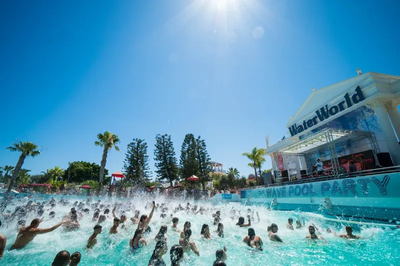 Foule dans une piscine avec une scène et le nom WaterWorld