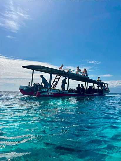 Bateau de plongée avec passagers sur une mer turquoise ensoleillée