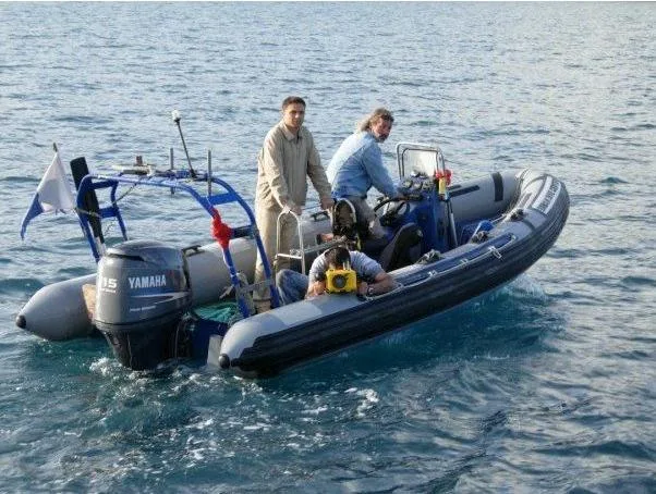 Trois personnes à bord d'un bateau semi-rigide sur l'eau calme