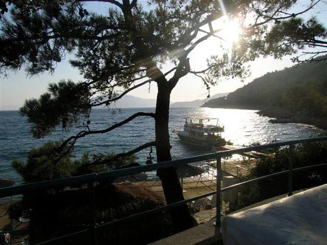 Vue sur la mer, un bateau amarré et un paysage côtier ensoleillé