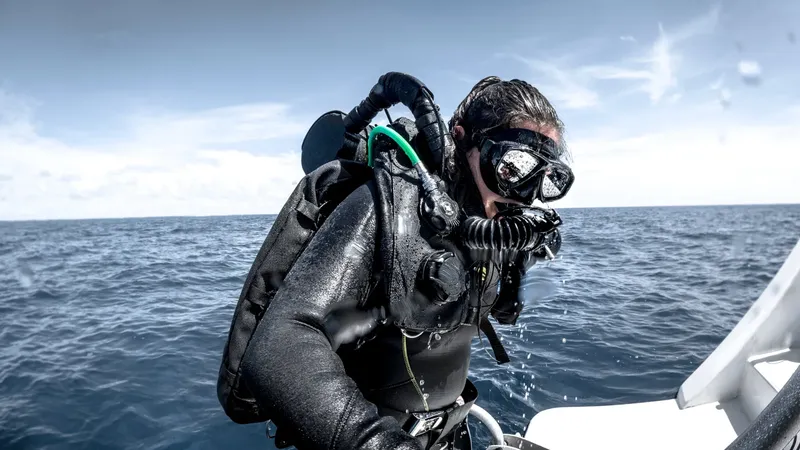 Plongeur s'apprête à entrer dans l'eau depuis un bateau en mer