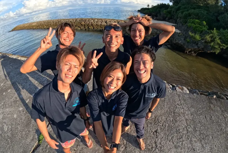 Groupe de personnes souriantes faisant des signes de la main au soleil