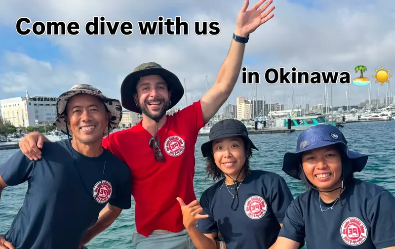 Quatre personnes souriantes sur un bateau avec le texte 'Come dive with us'