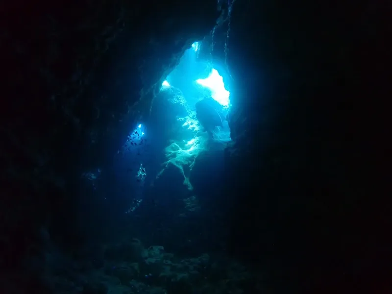 Vue sous-marine d'une grotte éclairée par la lumière du soleil