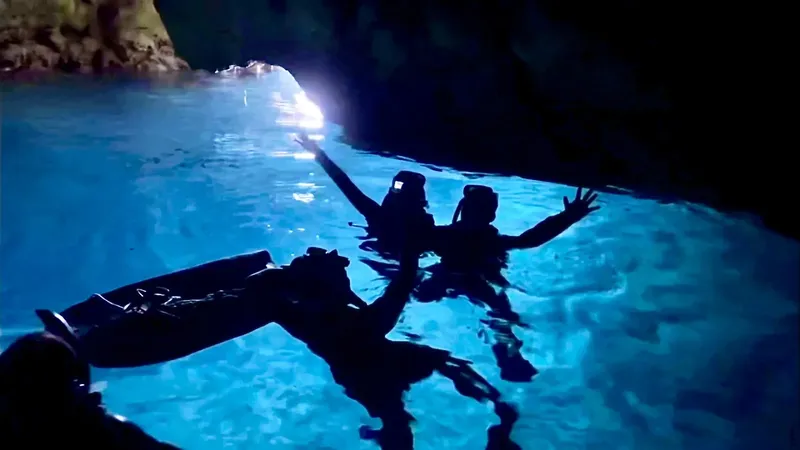 Plongeurs en silhouette dans une grotte sous-marine éclairée