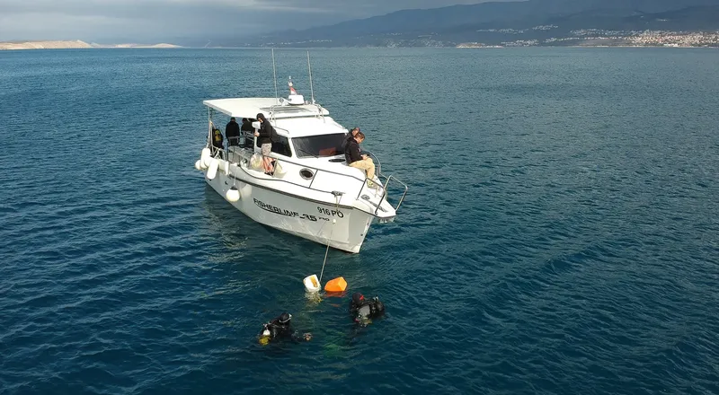 Bateau de plongée avec des plongeurs en préparation dans une mer bleue