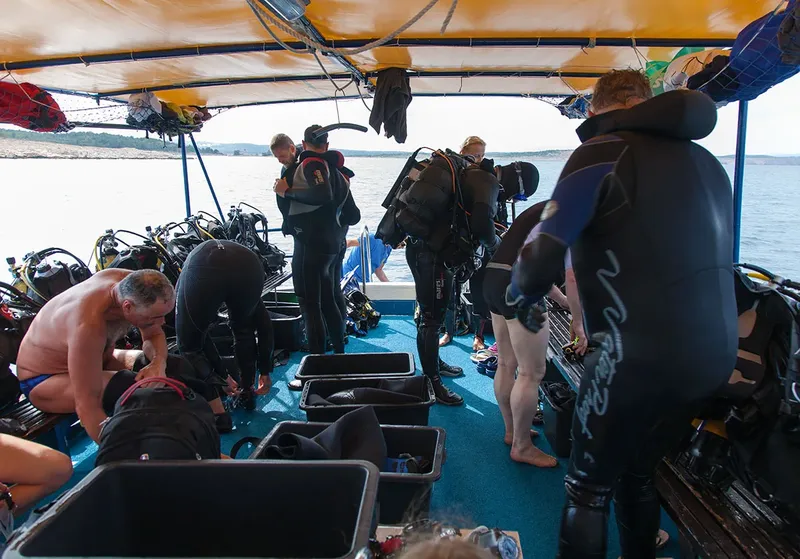 Plongeurs se préparant sur un bateau avec leur équipement complet