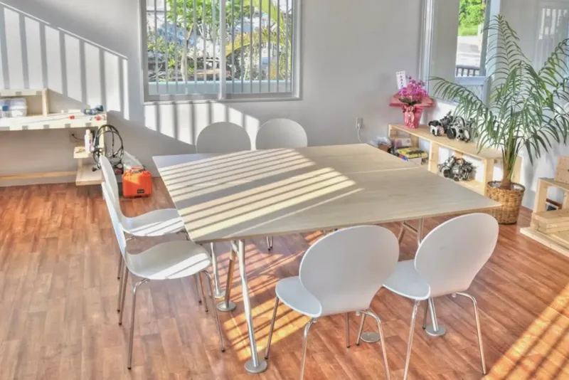 Grande table blanche et chaises blanches dans une pièce lumineuse
