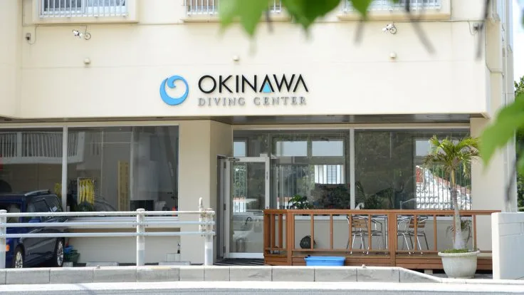 Façade d'un centre de plongée avec son logo et une terrasse