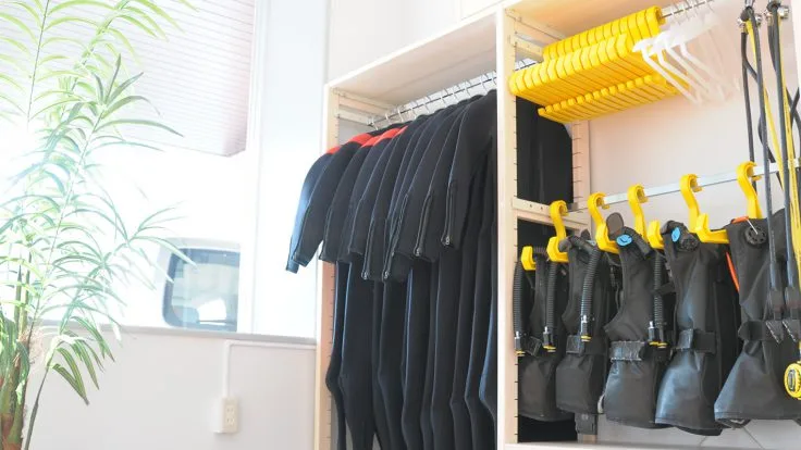 Combinaisons de plongée noires et gilets de sauvetage jaunes rangés