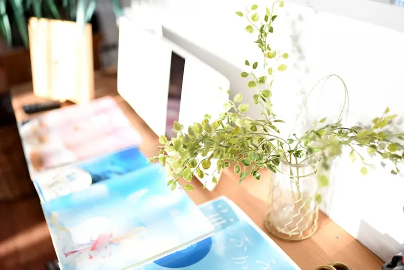 Table en bois avec des magazines, une plante et un vase transparent