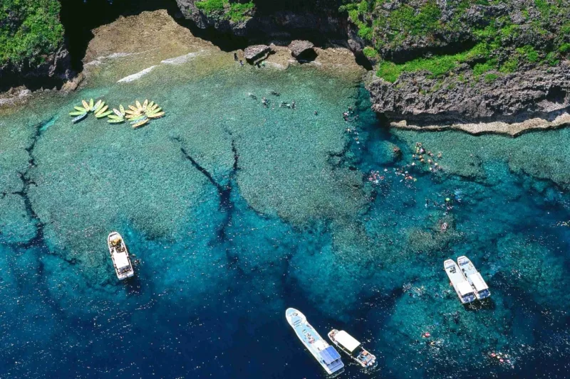 Plongée en mer turquoise avec plusieurs bateaux et des nageurs