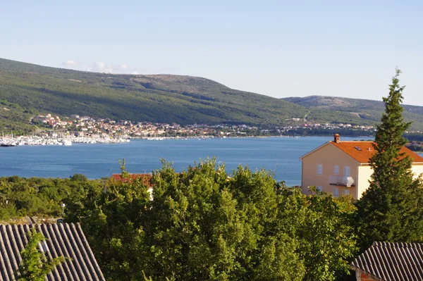 Vue d'une ville côtière avec un port de plaisance et des collines