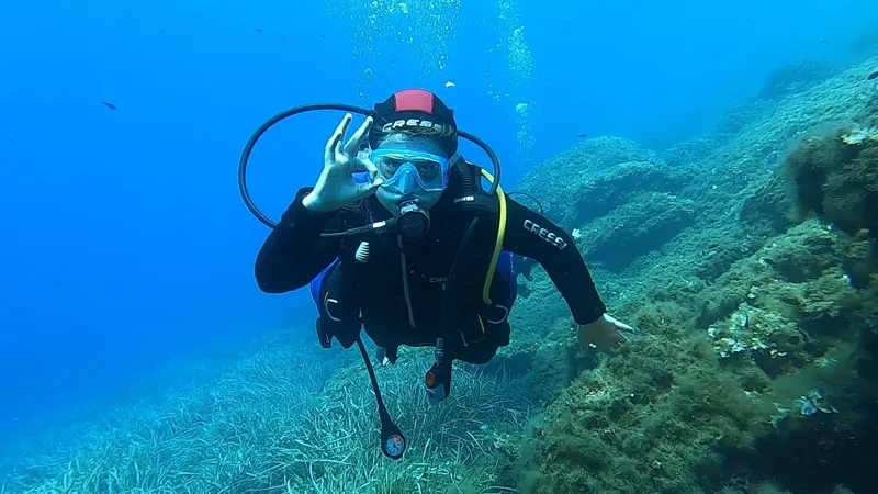 Plongeur souriant avec signe OK, exploration sous-marine en milieu naturel
